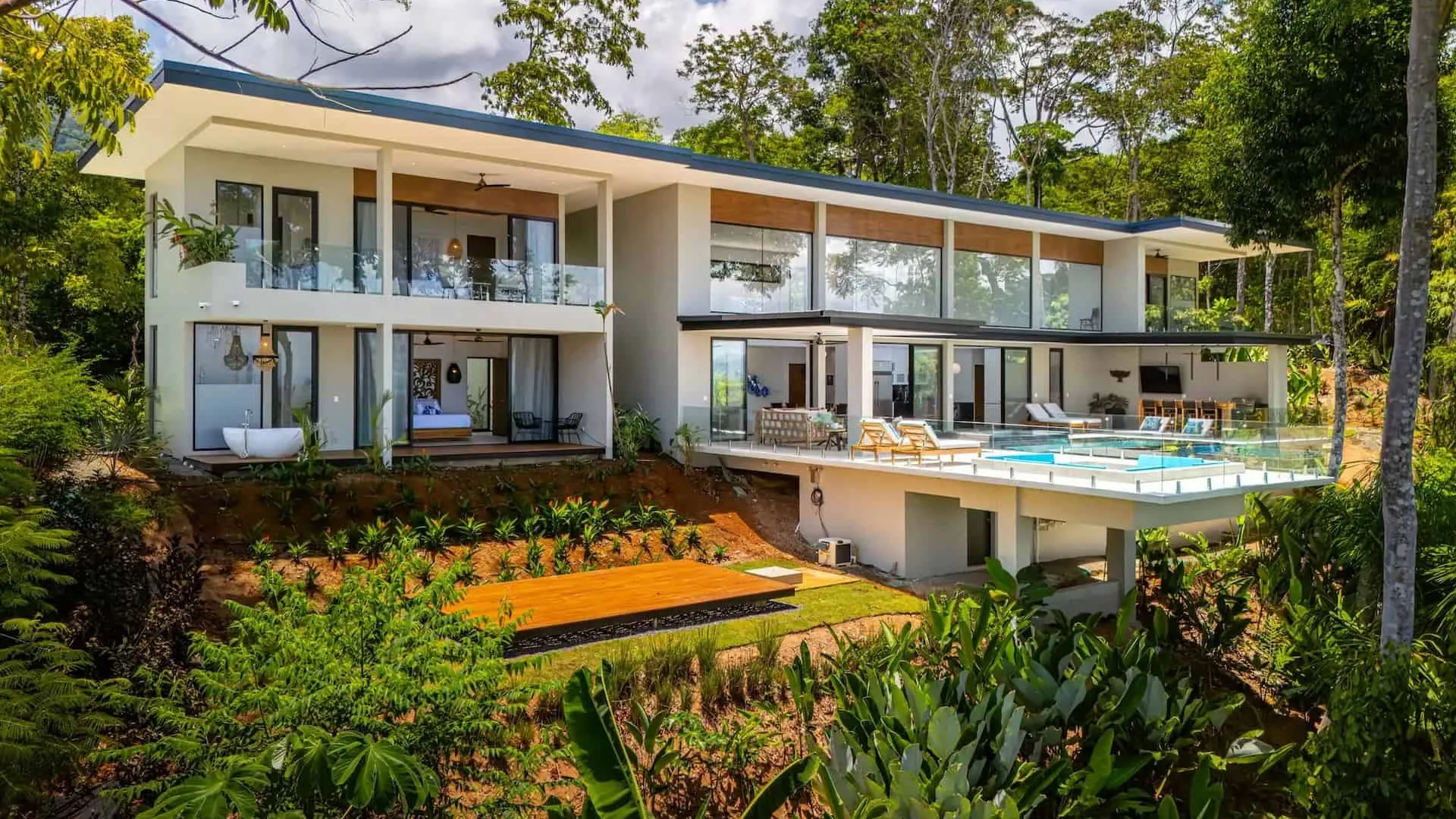 Exterior painting Costa Rica — freshly painted villa with rendered walls and tropical garden in the background